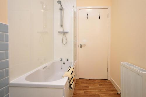 InnellanPedals and Paddles的带淋浴的浴室配有白色浴缸。