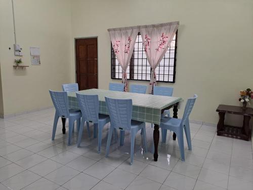 大港Room/Homestay NazaDja的用餐室配有带粉红色花卉的桌椅