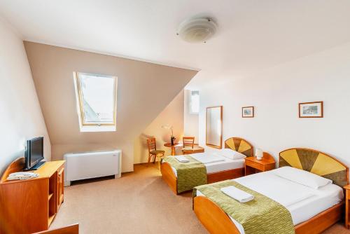 布达佩斯布达佩斯巴罗斯城市酒店的酒店客房设有两张床和电视。