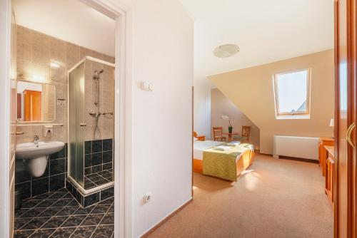 布达佩斯布达佩斯巴罗斯城市酒店的一间带水槽的浴室和一张位于客房内的床