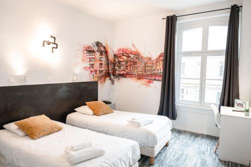 斯特拉斯堡Hotel des Arts - Centre Cathédrale的一间卧室设有两张床和一扇带绘画的窗户。