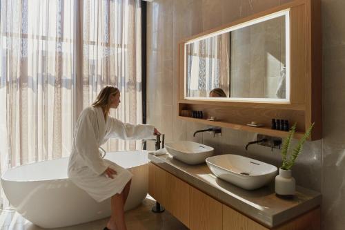 帕福斯Minthis Resort的坐在浴室浴缸里的女人