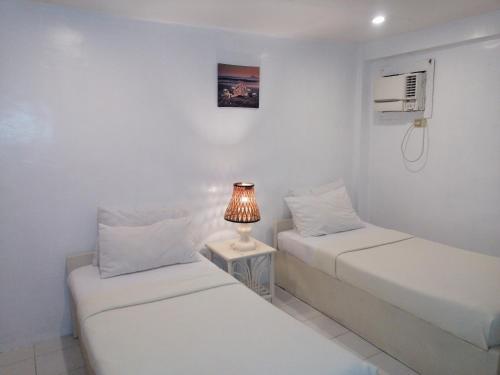 长滩岛海鸟国际度假村的一张桌子上灯的房间里两张床铺