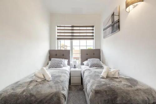 HornchurchLuxury 3-Bed Apartment Near To London With Parking的带窗户的客房内的两张床