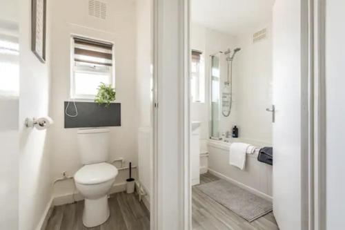 HornchurchLuxury 3-Bed Apartment Near To London With Parking的白色的浴室设有卫生间和浴缸。
