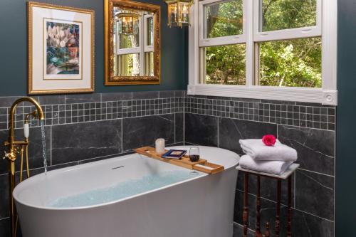 尤里卡斯普林斯Arsenic and Old Lace Bed & Breakfast Inn的带浴缸的浴室和2扇窗户