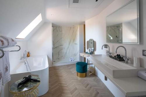 伊亚厄塞尔恩Hotel des Berges, Restaurant Gastronomique & Spa的白色的浴室设有浴缸、水槽和浴缸。