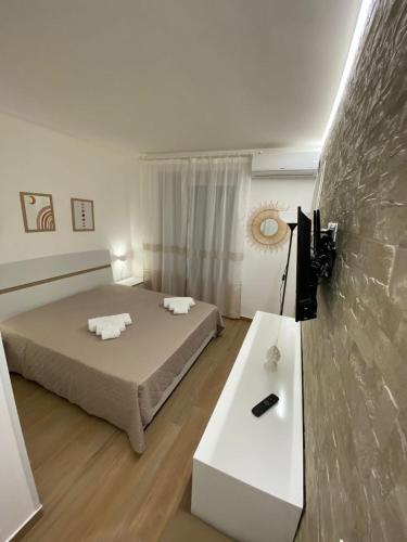 阿格里真托Dimora Garibaldi Apartment & Room的客房设有两张床、一张桌子和电视。