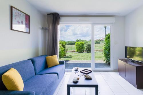 热尔扎克莱蒙费朗 - 格尔扎特花园和城市公寓的客厅配有蓝色的沙发和电视