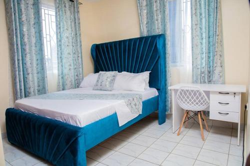 蒙巴萨Royal Haven A3 Spacious 1Br Apartment 10min drive to beach hosts upto 4 guests WiFi - Netflix, 10min drive to beach的卧室里一张带蓝色床头板的床