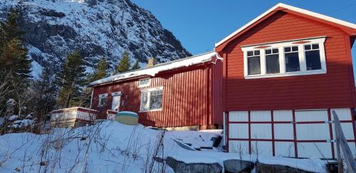 莫斯克内斯Moskenes Cabin的一座白雪 ⁇ 的红色房子