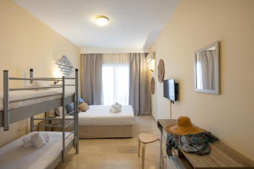 阿基奥斯·伊奥尼斯·佩里斯特Aurora Beach Hotel的客房设有两张双层床和一张桌子。