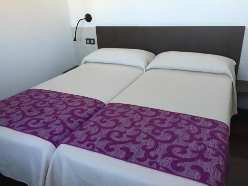 Boadilla del CaminoHotel Rural En El Camino的床上有紫色毯子