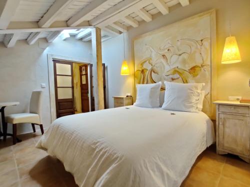 坎德拉里奥Posada Restaurante Casa de la Sal的卧室配有一张白色床,墙上挂有绘画作品