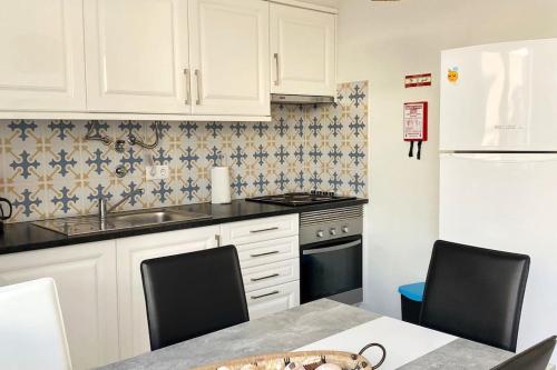 阿尔坎塔里利亚Casa Azul em Alcantarilha - Algarve的厨房配有白色橱柜、水槽和炉灶。