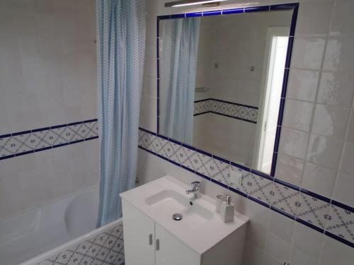 阿尔坎塔里利亚Casa Azul em Alcantarilha - Algarve的一间带水槽和镜子的浴室