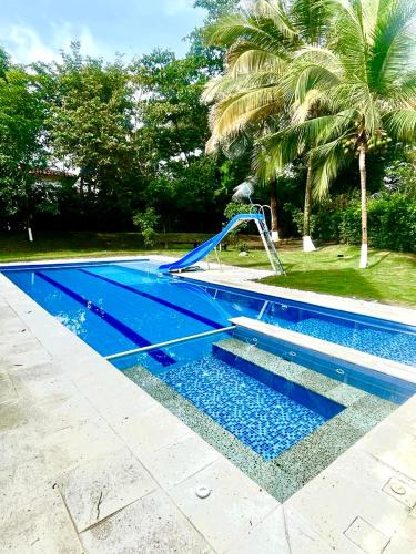 圣菲德安蒂奥基亚Cabaña en santafe de Antioquia的蓝色的游泳池,里面设有滑梯