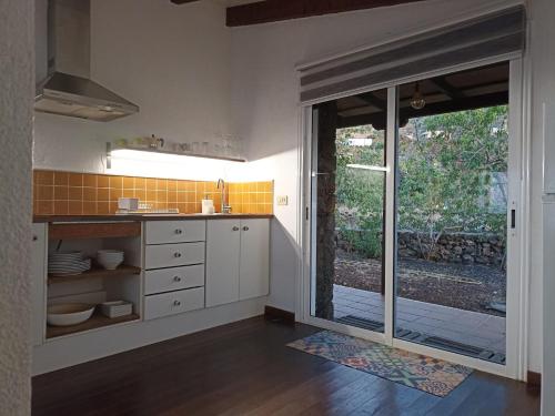 莫卡诺尔Dos Violetas的厨房配有白色橱柜和滑动玻璃门