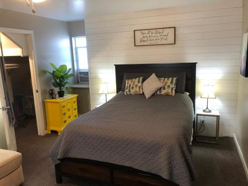 大章克申Cozy Studio的一间卧室设有一张大床和一个黄色床头柜