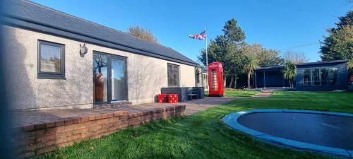 索尔特科茨Laighdykes Guest Cottage的院子旁的房屋,有红色电话亭