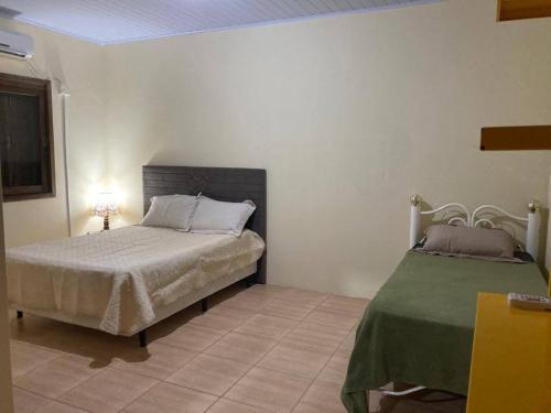 南圣洛伦索Barrinha dos Ventos的一间卧室配有一张床和绿毯