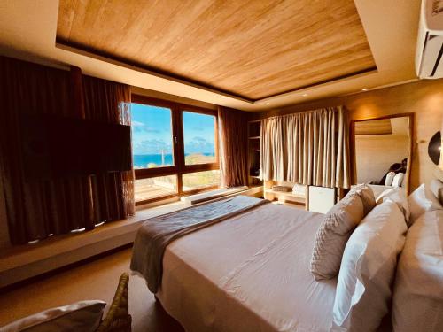 费尔南多 - 迪诺罗尼亚POUSADA DO MIRANTE的一间卧室设有一张大床和一个大窗户