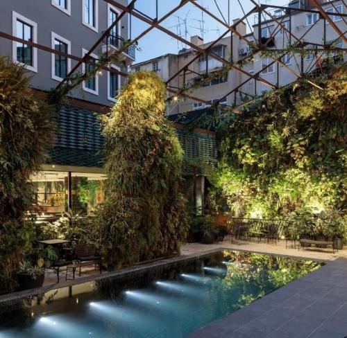 里斯本Hotel Hotel - Member of Design Hotels的一座带游泳池的庭院,位于一座建筑中
