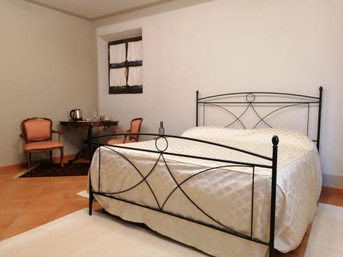 Serravalle delle LangheLA CASA DI TALIN的卧室配有1张床、1张桌子和1把椅子