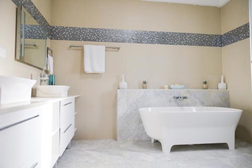 BakauAtlantic Luxury Apartments的浴室配有白色浴缸和2个盥洗盆