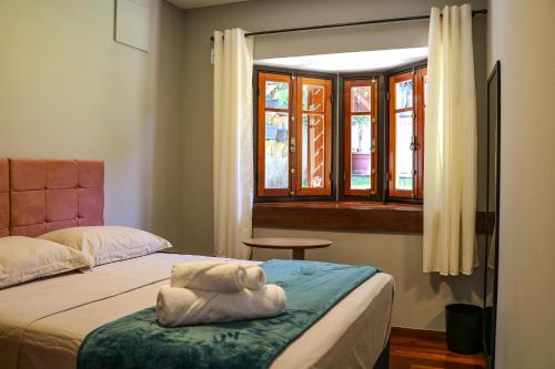 弗洛里亚诺波利斯Hostel Jardim das Bruxas 410的一间卧室设有两张床和窗户。