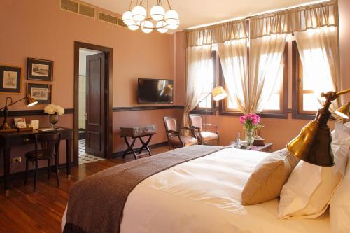圣地亚哥Hotel Boutique Castillo Rojo的卧室配有一张白色大床、一张桌子和一张桌子
