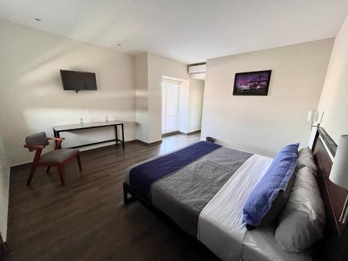 圣胡安－德洛斯拉戈斯Hotel Refugio的一间卧室配有一张床、一张桌子和一张桌子
