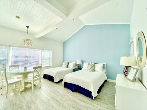 比奇港迎温沃德海滩宾馆的一间带两张床和一张桌子的卧室以及一间用餐室