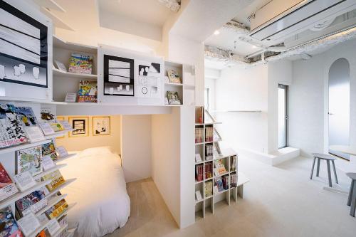 东京BOOK HOTEL 神保町的一间设有床和书架的房间