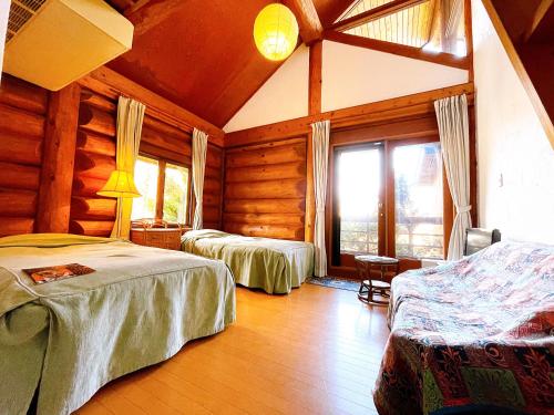 白马村Hakuba Pension & Log Hotel Meteor的小木屋内一间卧室,配有两张床