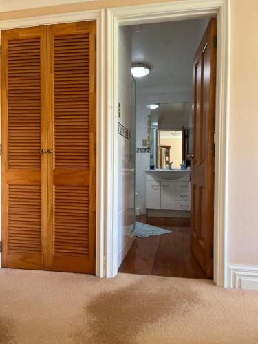 旺阿雷Tamaterau Seaview House in Whangarei的走廊上设有通往浴室的门