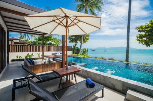 波普托Peace Resort Samui的游泳池旁的天井配有桌子和遮阳伞