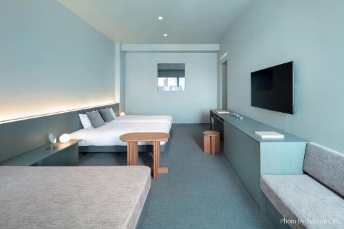 东京KAIKA TOKYO by THE SHARE HOTELS的酒店客房设有两张床和一台平面电视。