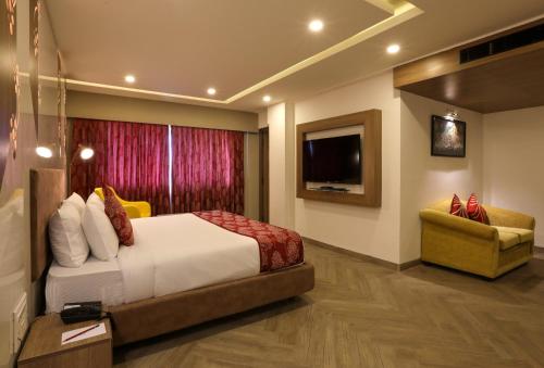 钦奈Mango Hill Central Chennai的酒店客房,配有床和电视