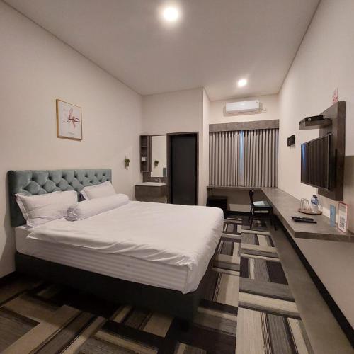 雅加达3 Point Syariah Residence的一间卧室配有一张大床和一张书桌