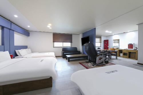 全州市XO Hotel的一间带两张床的卧室和一间客厅