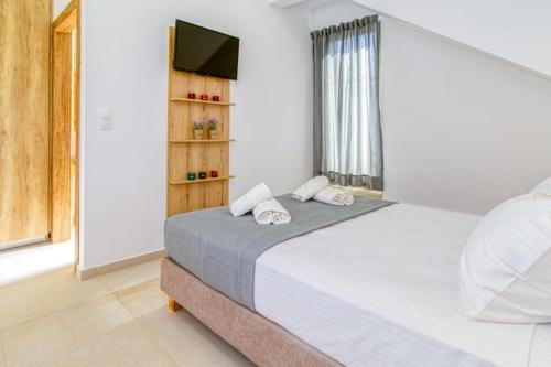 马莱迈Cocoon Luxury Villas的一间卧室配有一张大床和电视