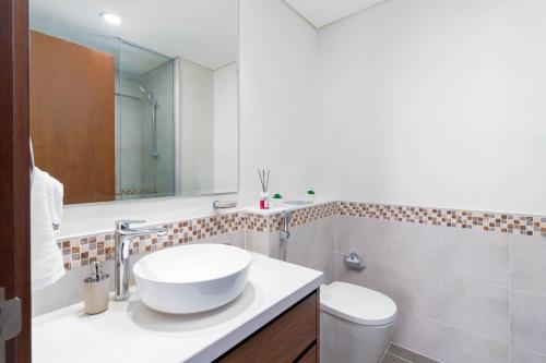 迪拜Delightful 2BR apartment at Reva Residences的白色的浴室设有水槽和卫生间。