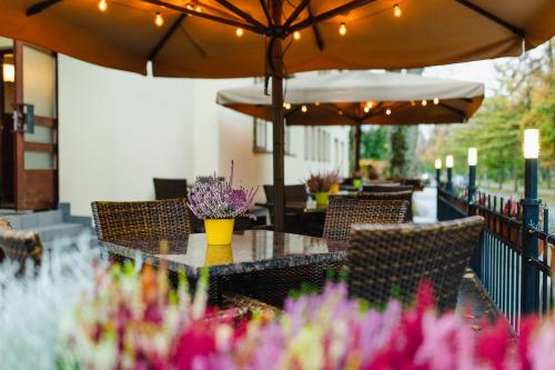派尔努传奇酒店的一个带桌椅、遮阳伞和鲜花的庭院
