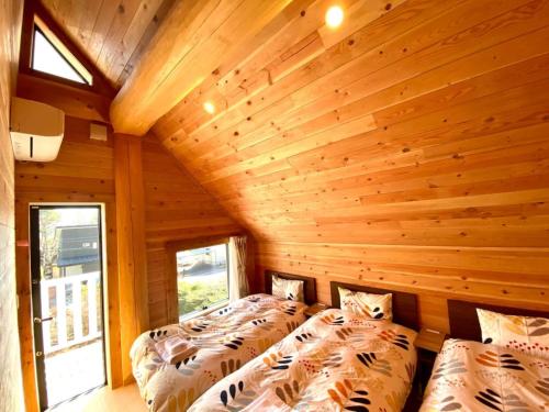 OiwakePolar Haus Canadian NishiKaruisawa1 - Vacation STAY 07669v的木墙客房的两张床