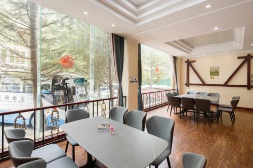 九寨沟九寨沟九寨之旅大酒店的餐厅设有桌椅和大窗户。