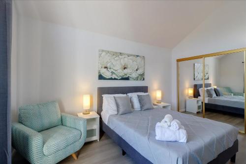海沃德@ Marbella Lane - 4BR City Escape in Hayward的一间卧室配有一张床、一把椅子和镜子