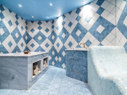 帕福斯莱昂纳多广场塞浦路斯马里斯海滩酒店及Spa的蓝色和白色的浴室设有浴缸和水槽