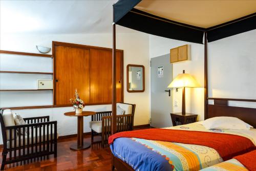 丰沙尔科伦坡公寓的卧室配有一张床和一张桌子及椅子