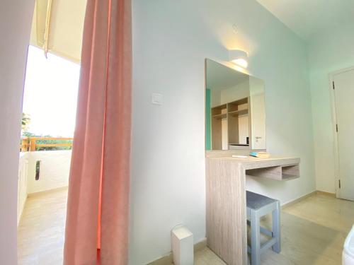 罗希姆诺Domenica Apartments的客房设有镜子、书桌和窗户。